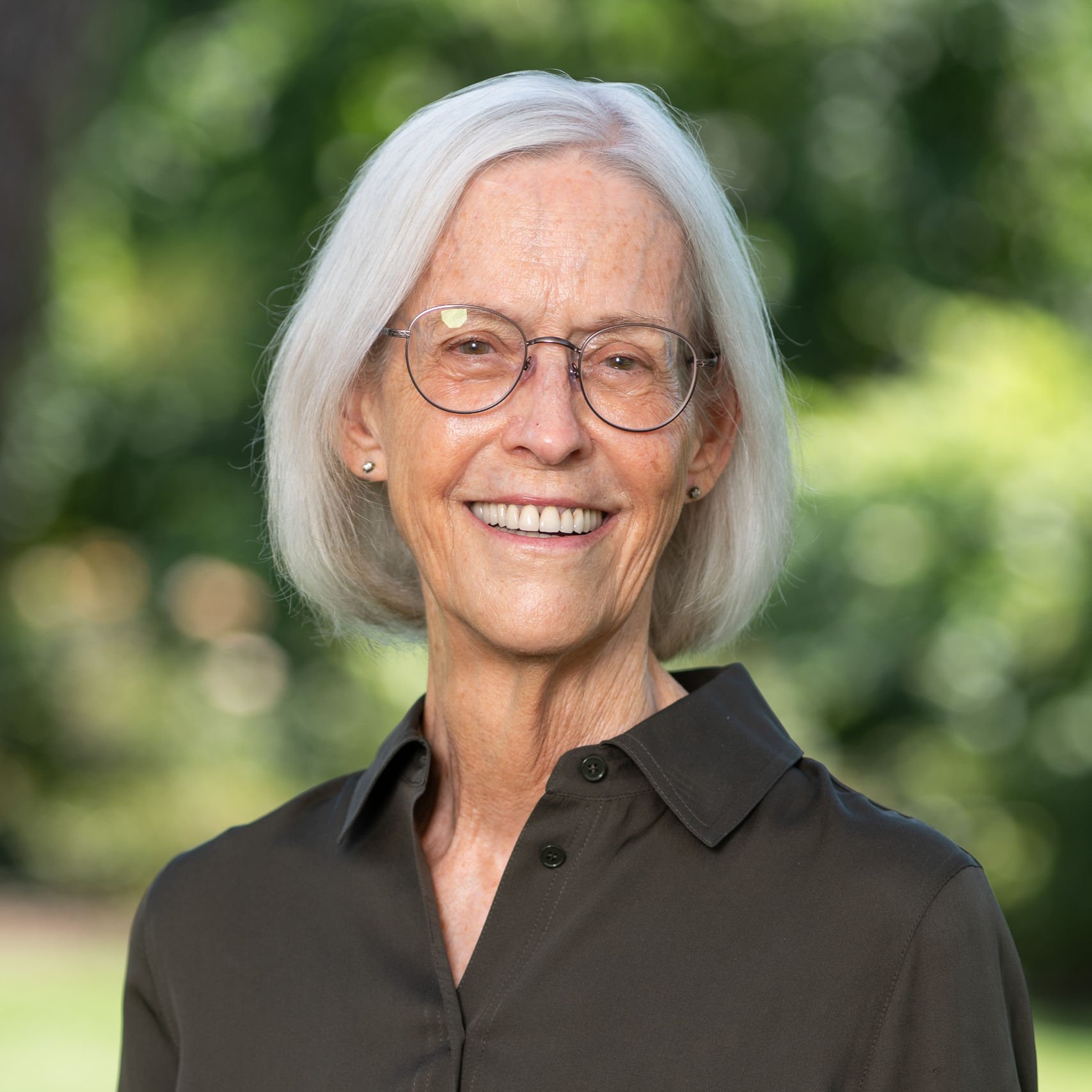 a woman with glasses smiling