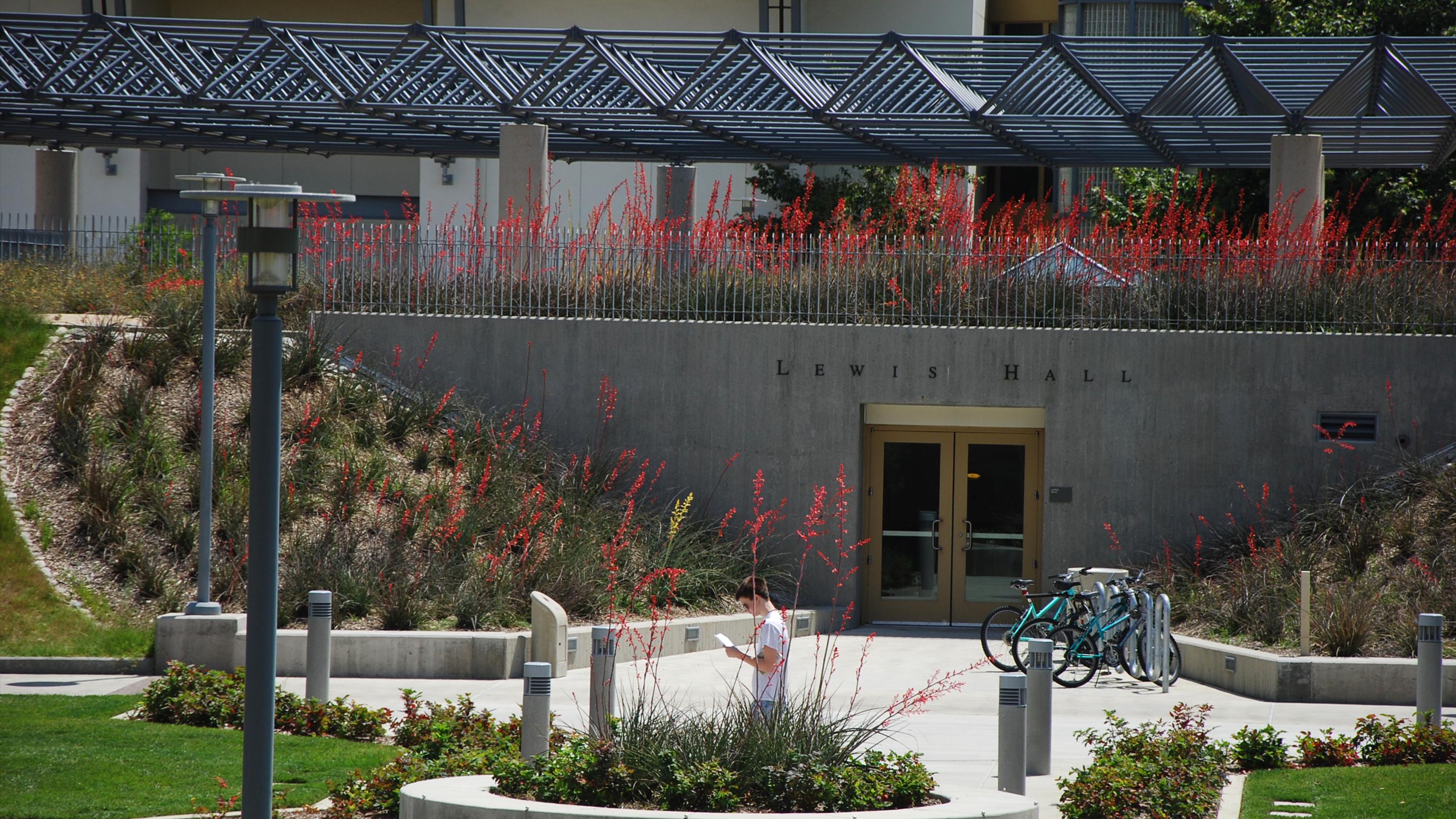 a man reading a book in front of a building