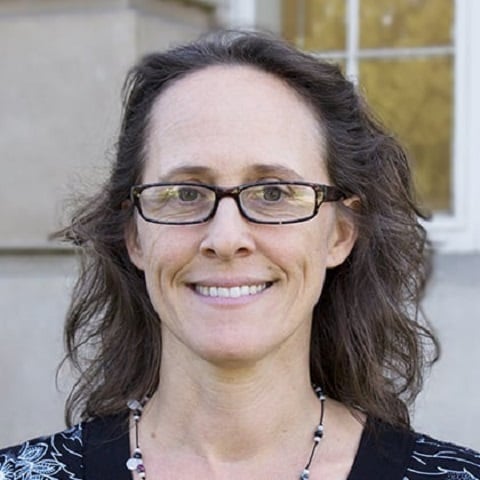 a woman wearing glasses and smiling