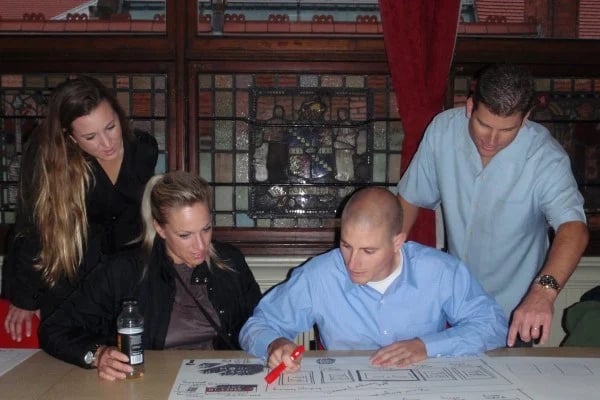 a group of people looking at a drawing