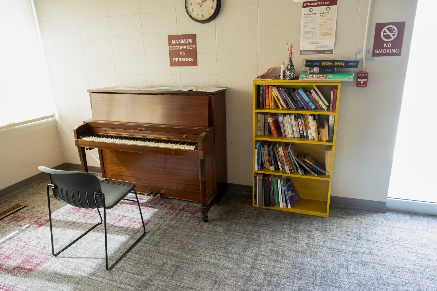 a piano next to a bookcase