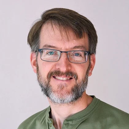 a man with glasses smiling