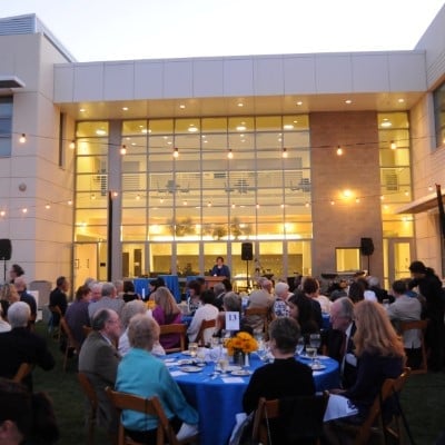 a group of people sitting at tables outside a building