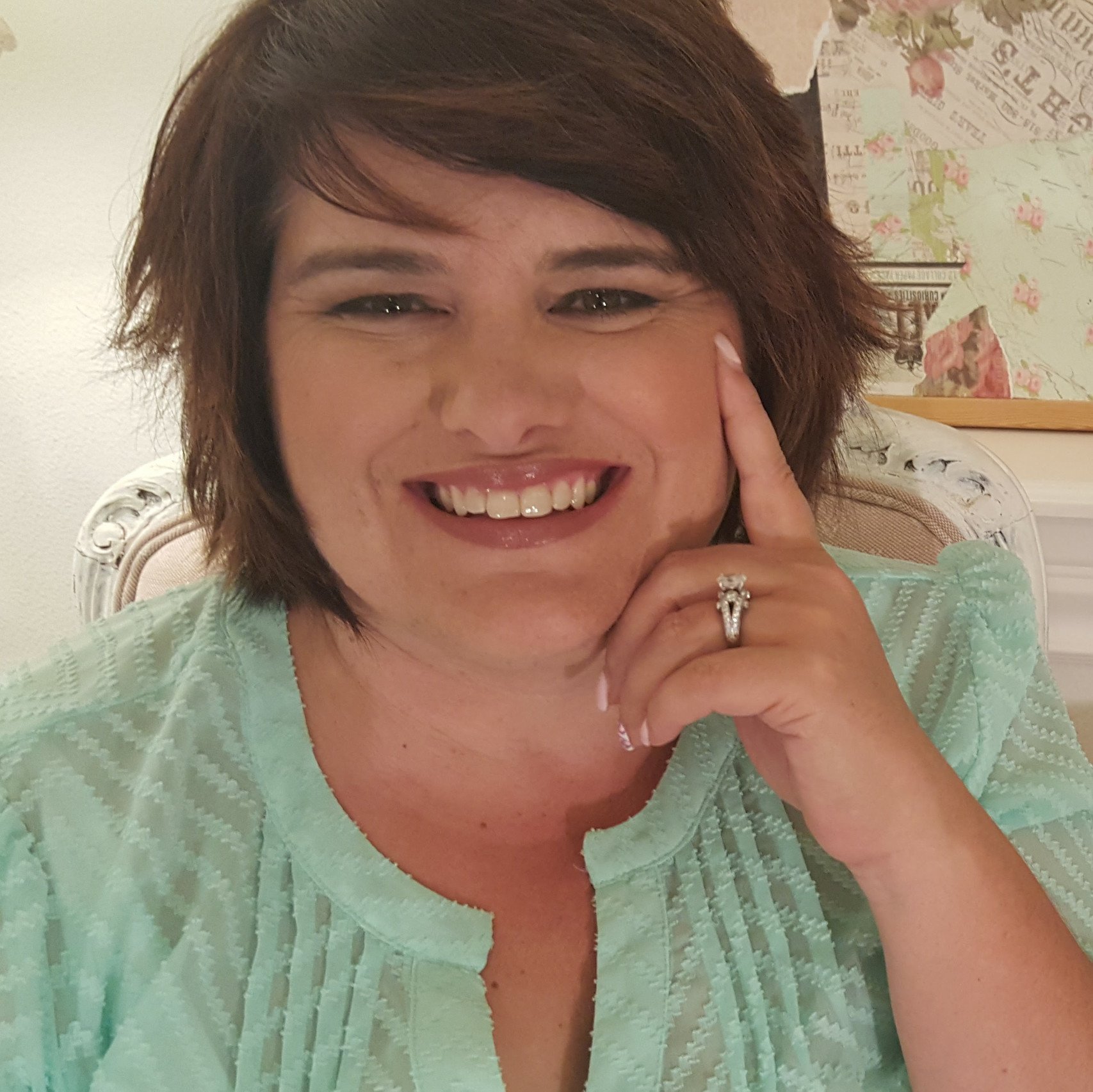 a woman smiling with her hand on her face