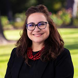 a woman wearing glasses and a red necklace