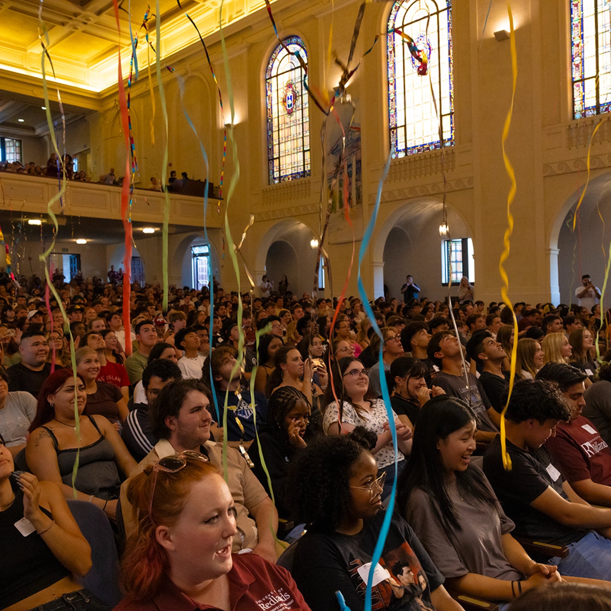 a group of people sitting in a room with streamers
