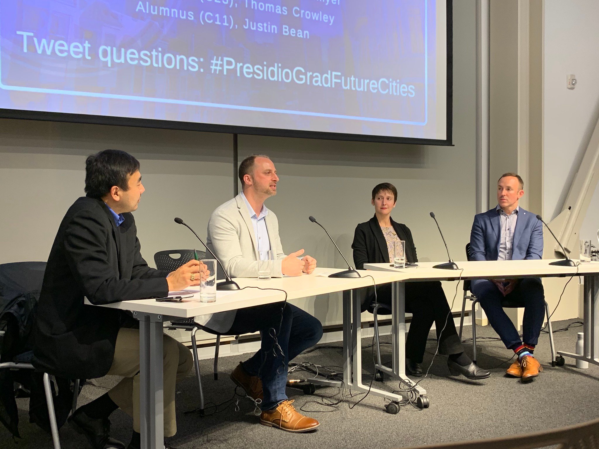 a group of people sitting at a table with microphones