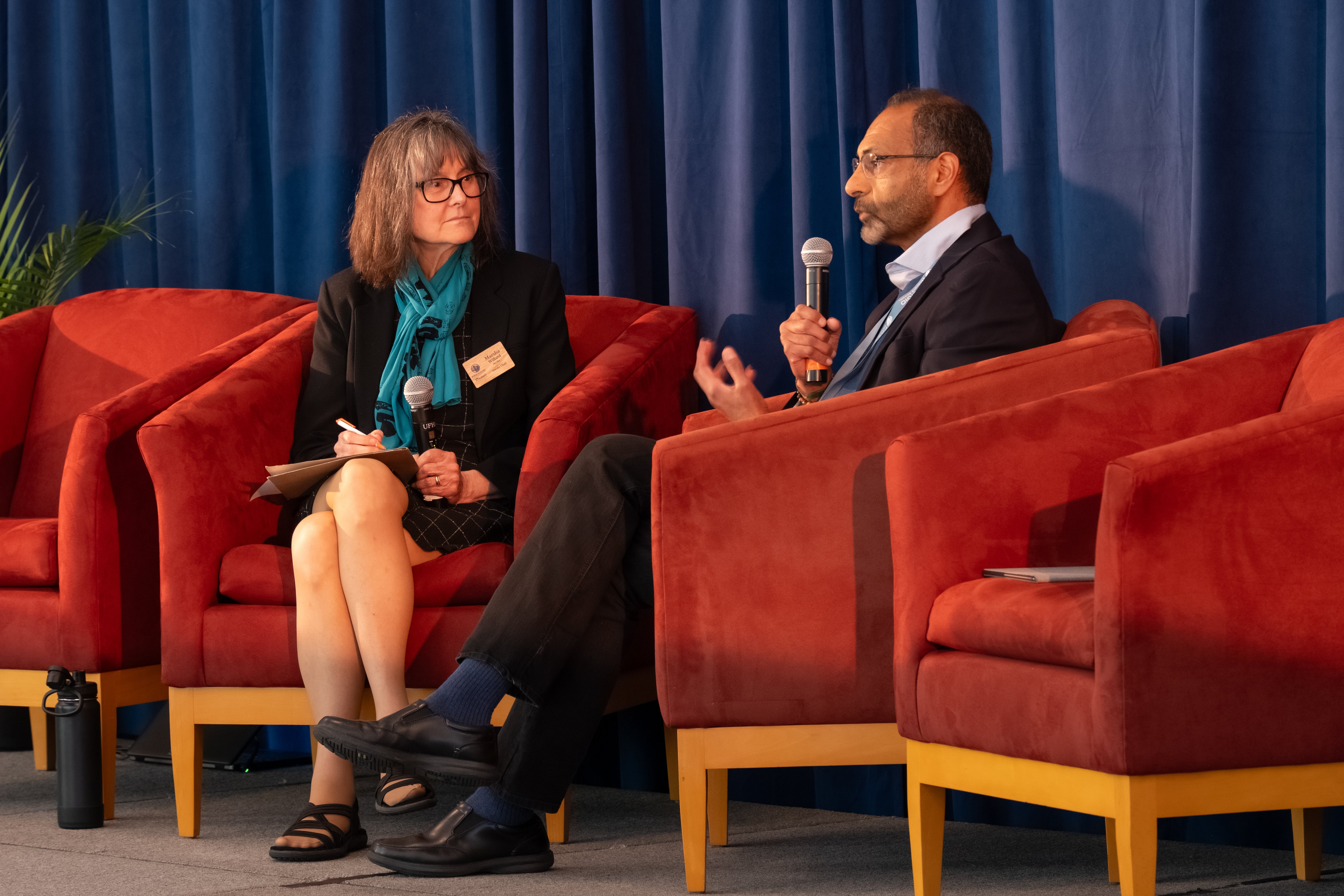 a man and woman sitting in chairs talking