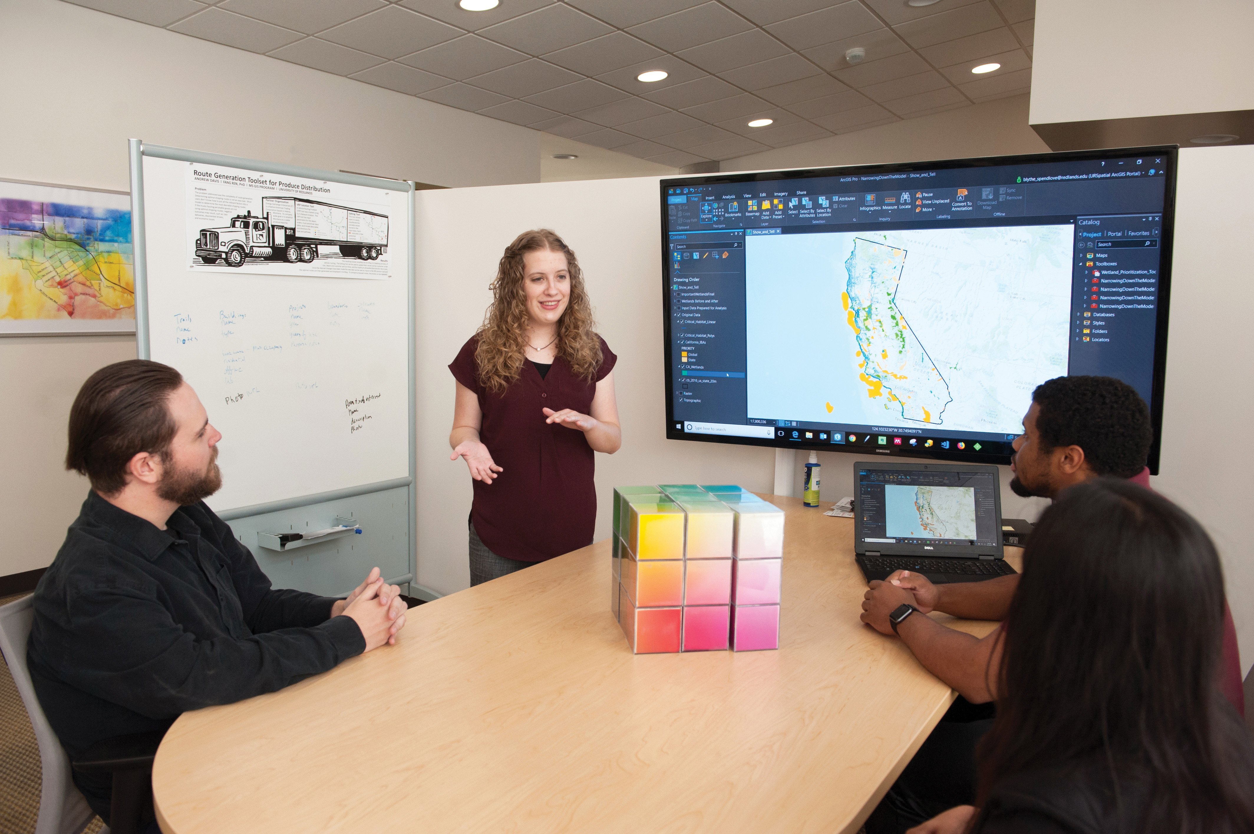 a woman standing in front of a large screen