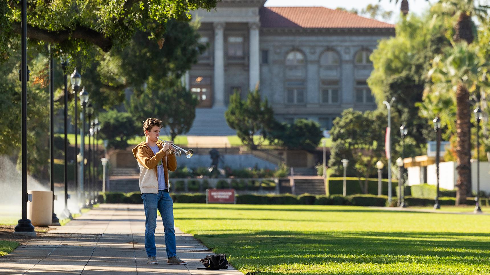 a man playing a trumpet in a park