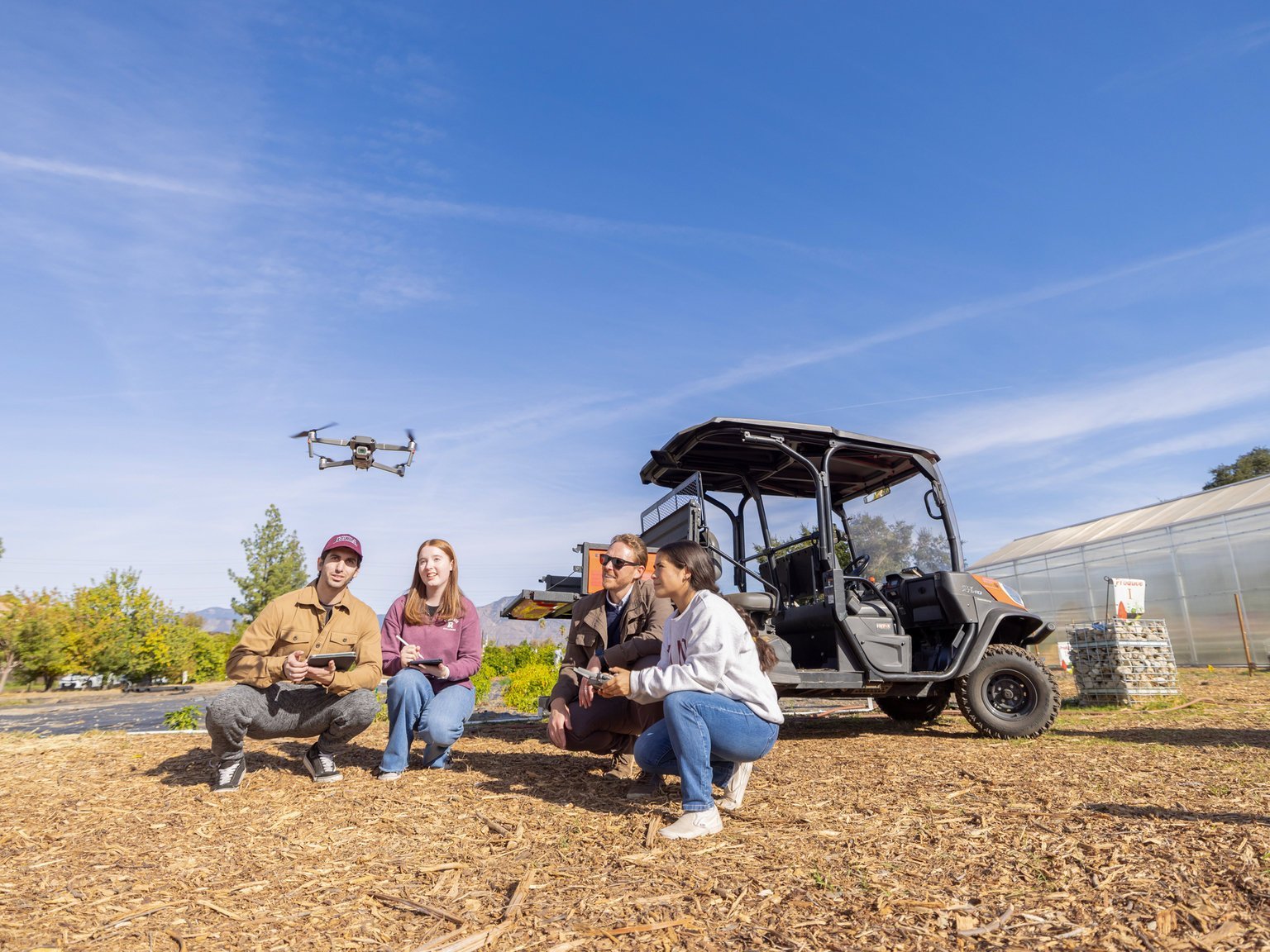 a group of people sitting next to a small vehicle