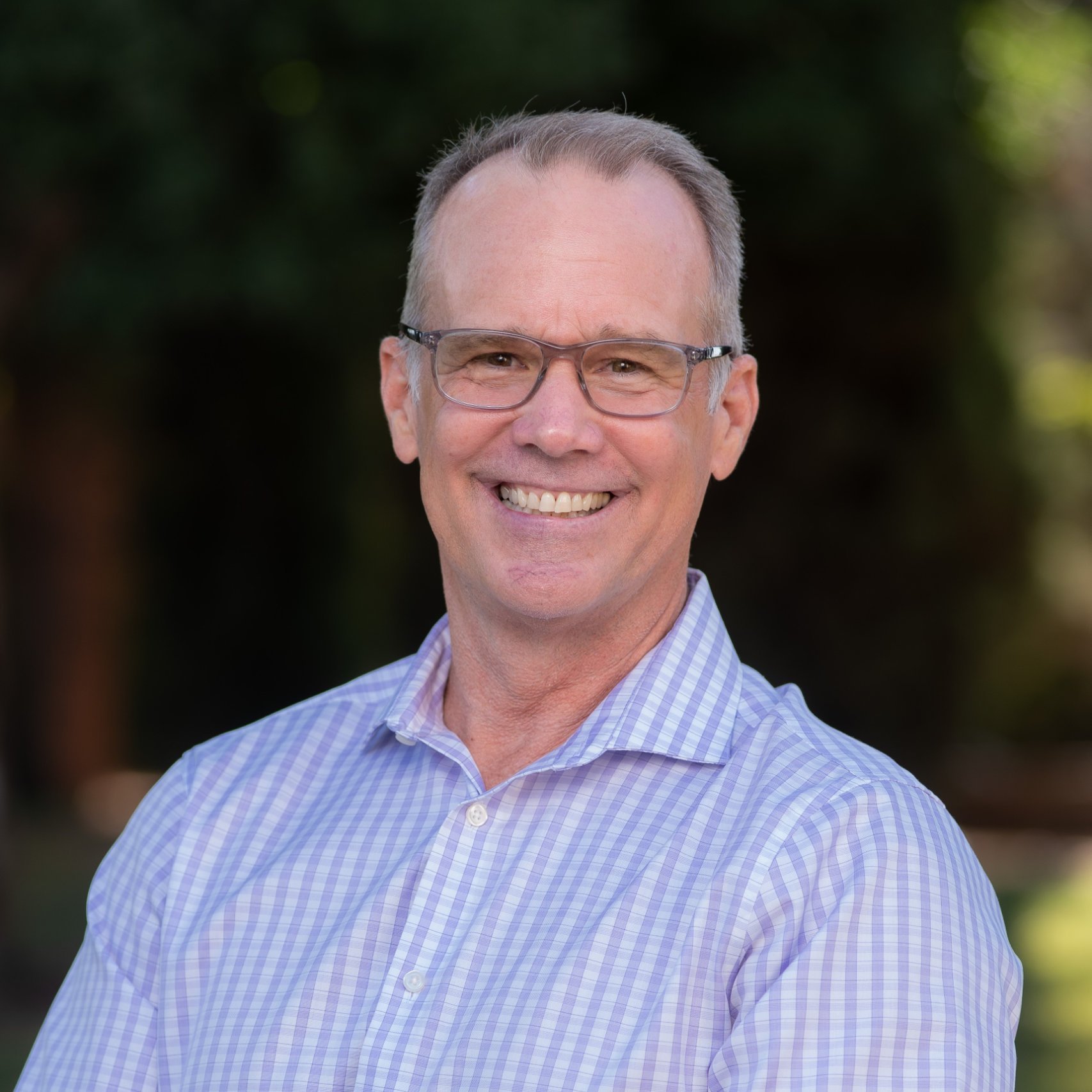 a person wearing glasses smiling
