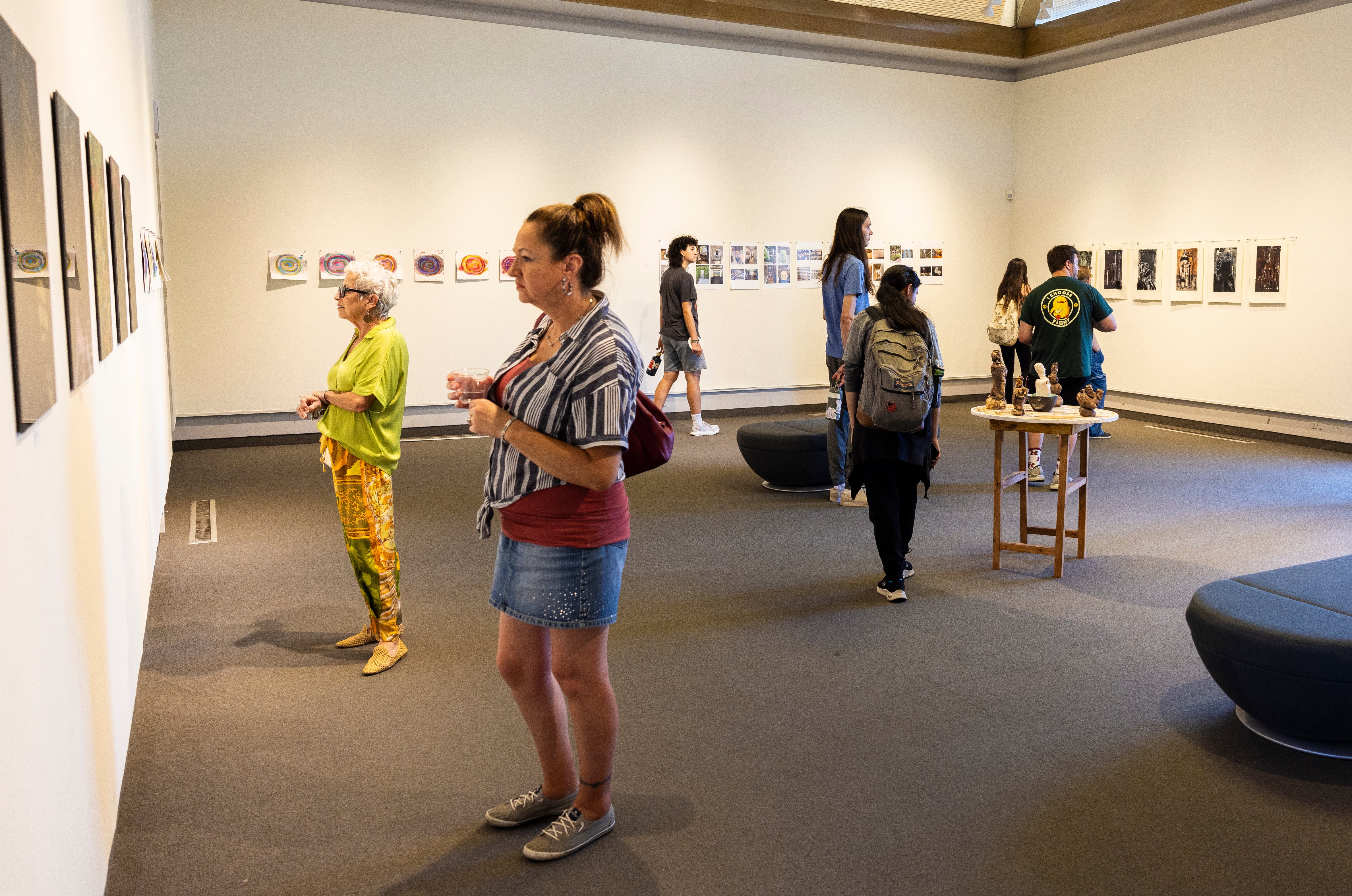 a group of people in a room with art on the wall