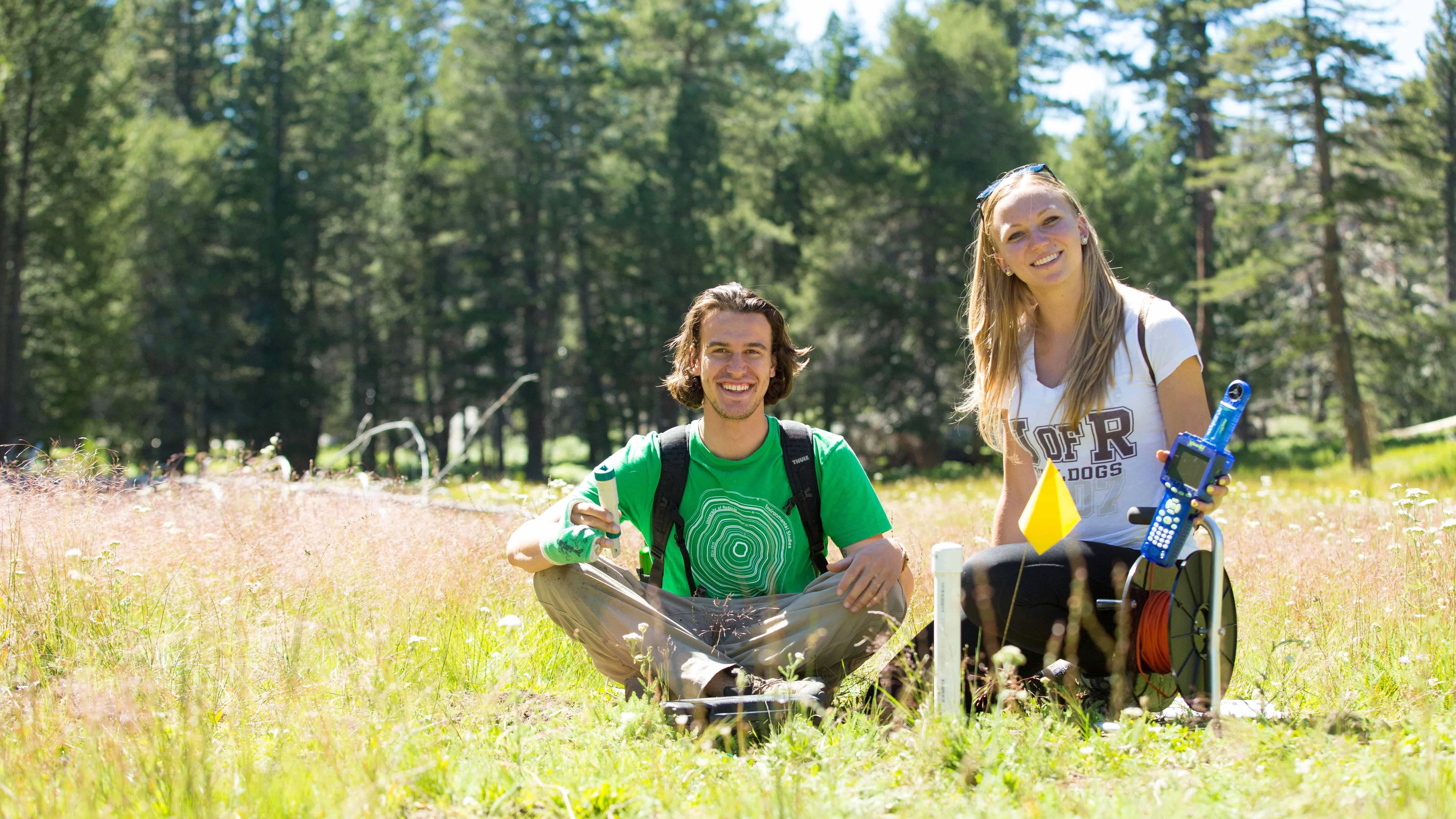 a man and woman sitting in a field