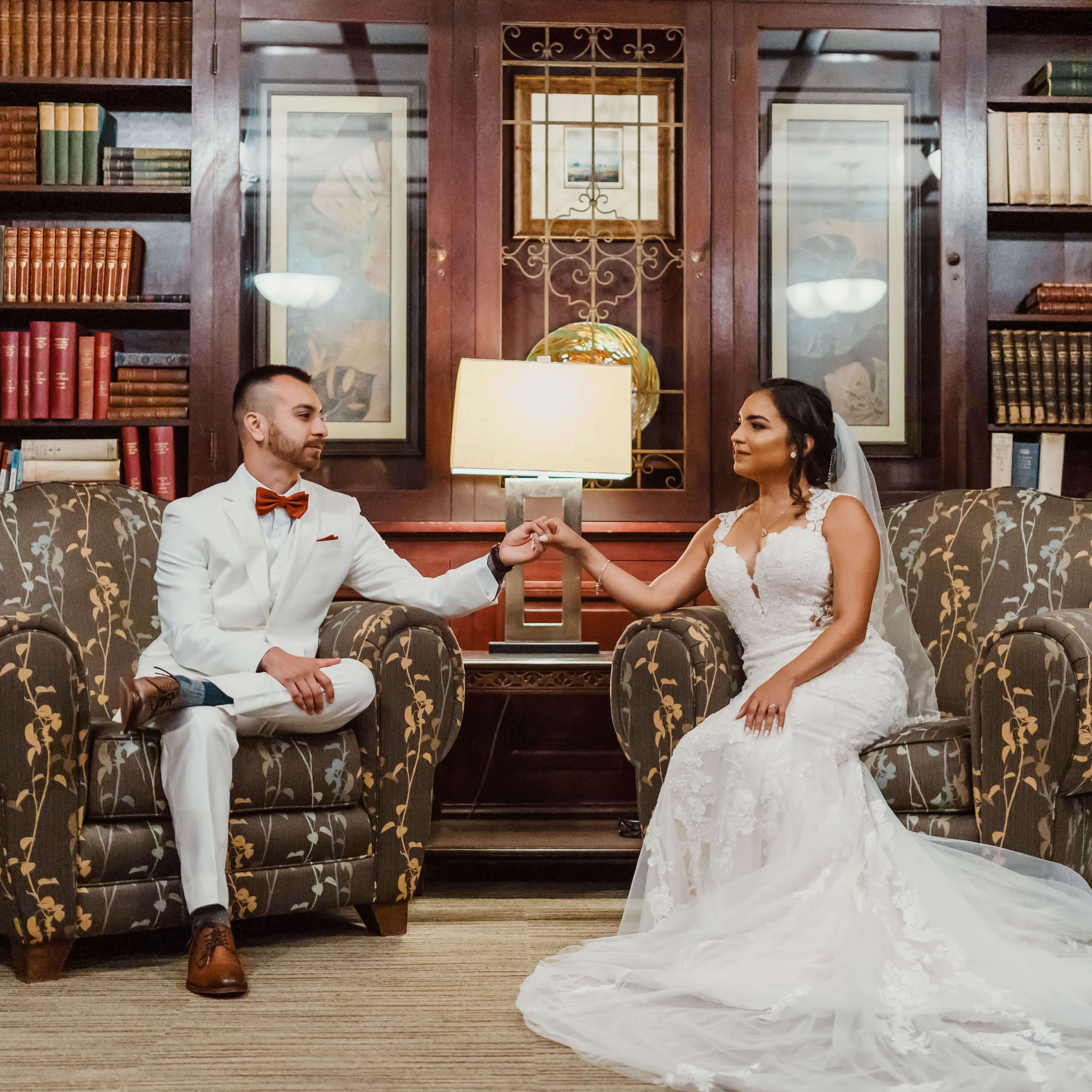 a man and woman sitting in chairs holding hands