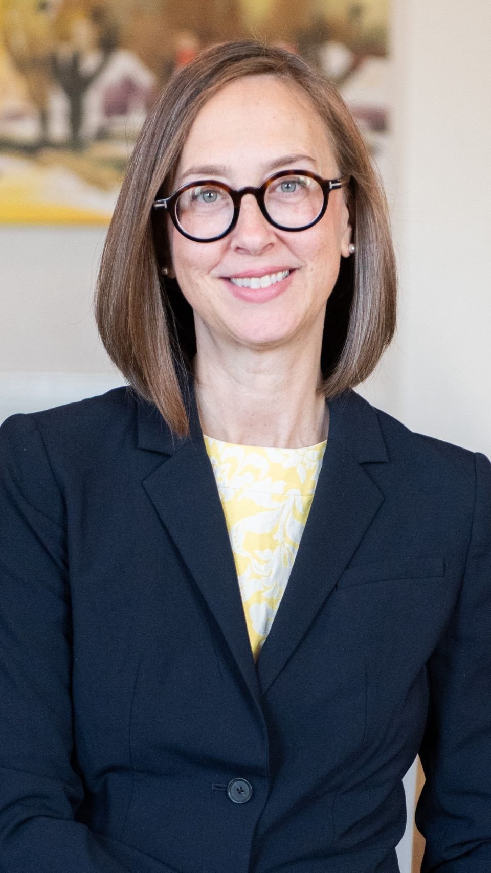 a woman wearing glasses and a suit