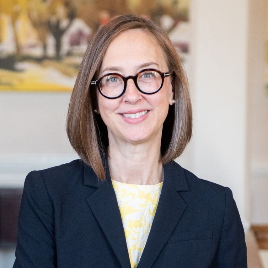 a woman wearing glasses and a black jacket