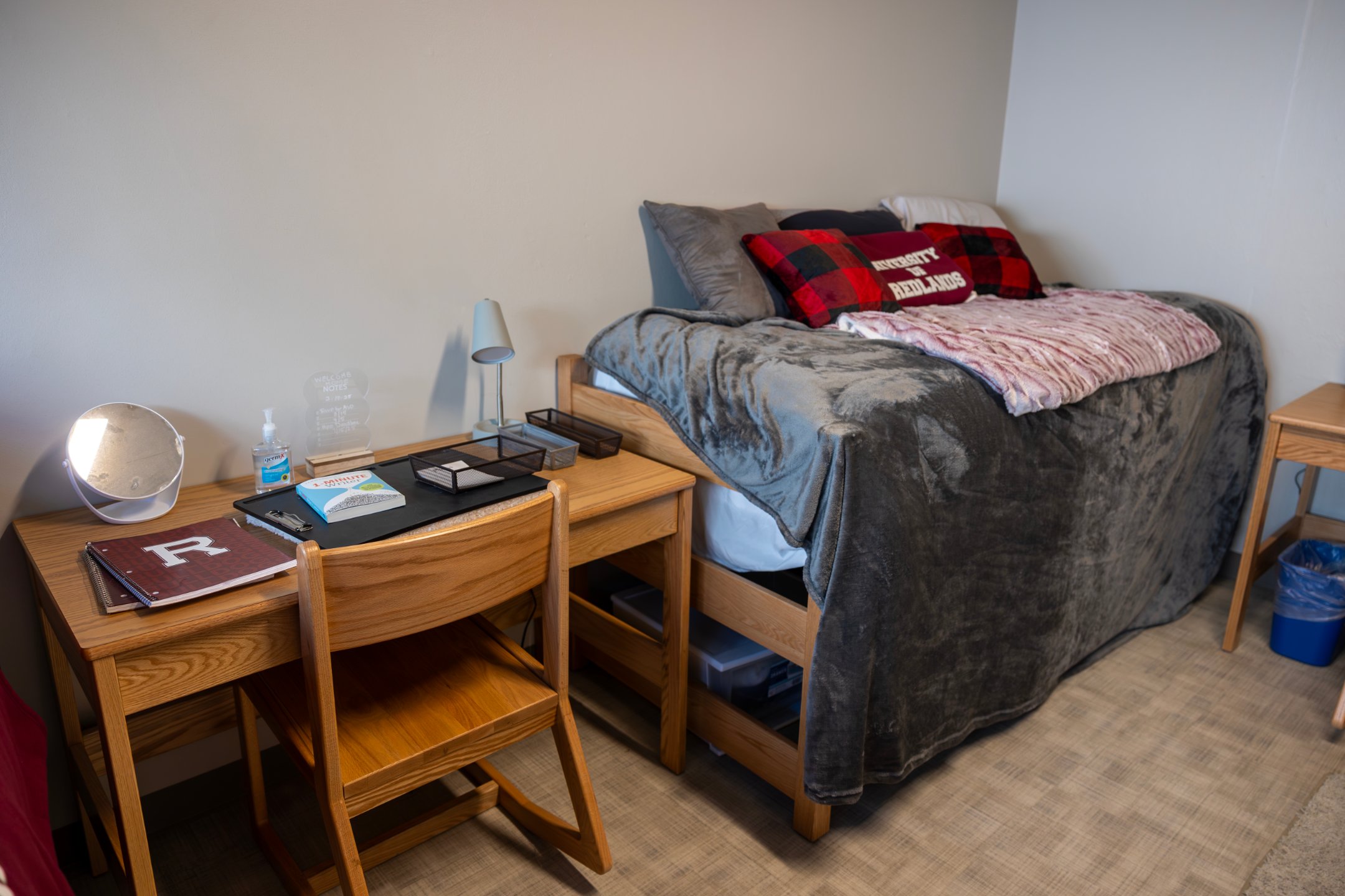 a bed with a desk and a lamp