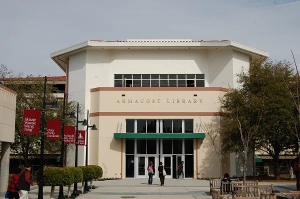 a library building with people walking in front of it