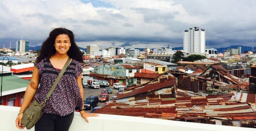 a person standing on a ledge with a city in the background