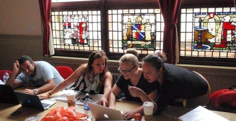 a group of women looking at a laptop