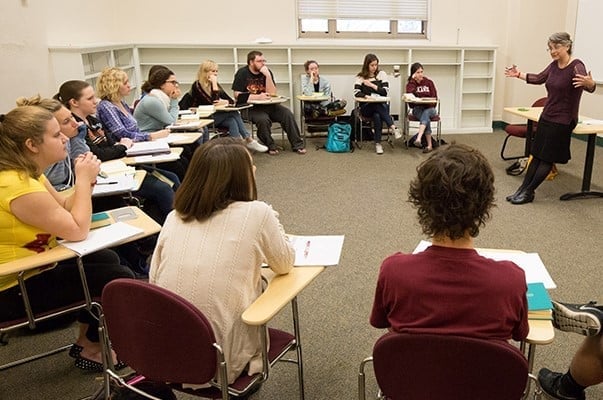a person standing in front of a group of students