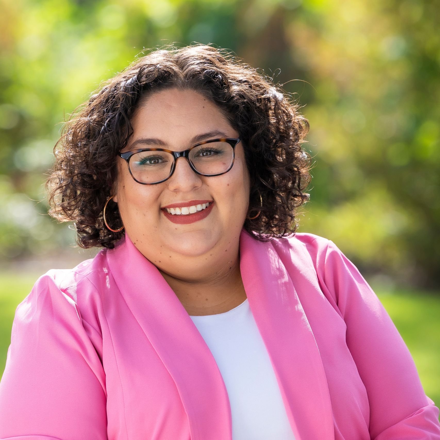 a woman wearing glasses and a pink jacket