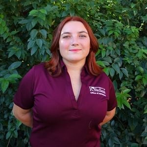 a woman standing in front of a bush