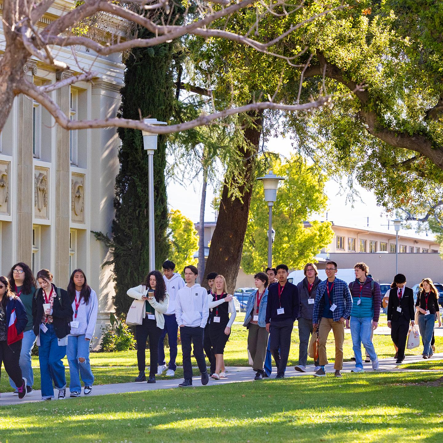 a group of people walking on a sidewalk