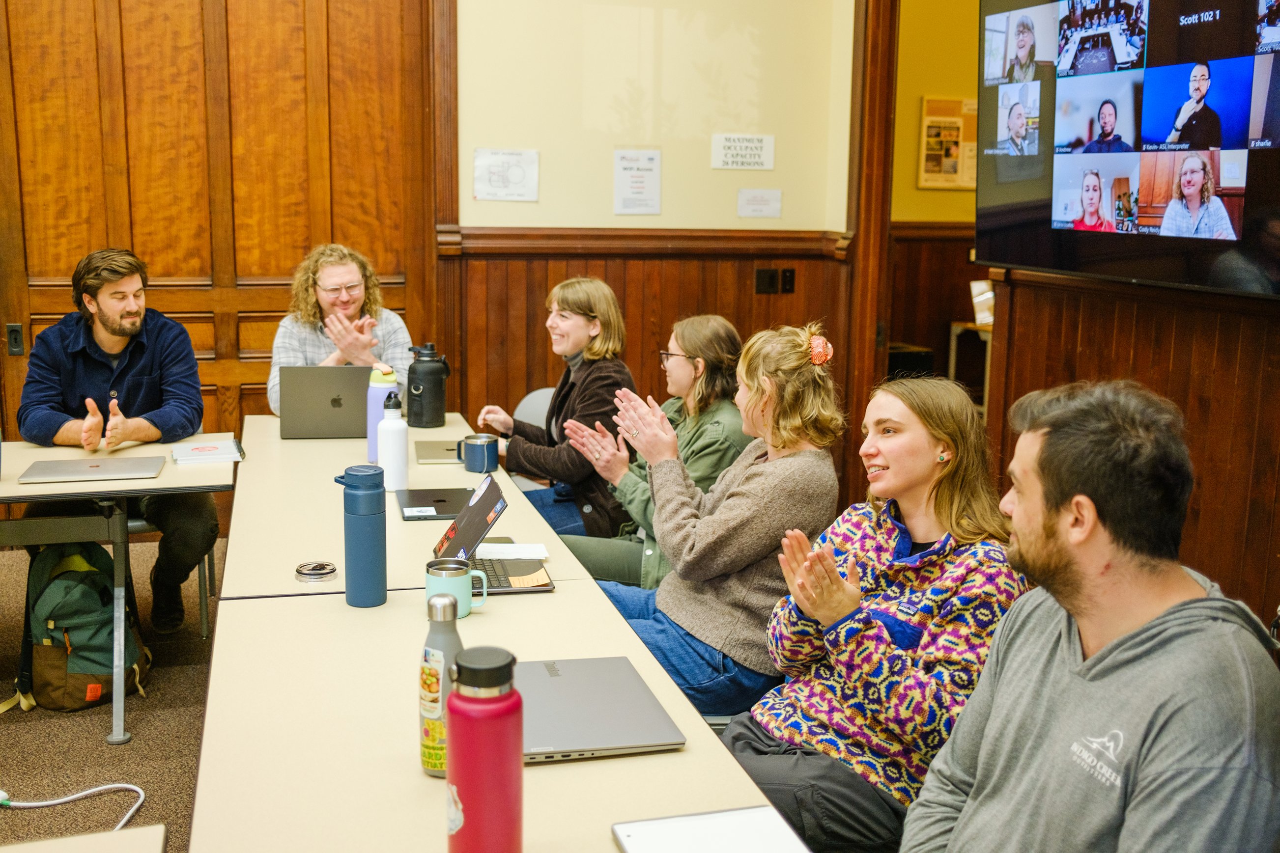 a group of people clapping in a room