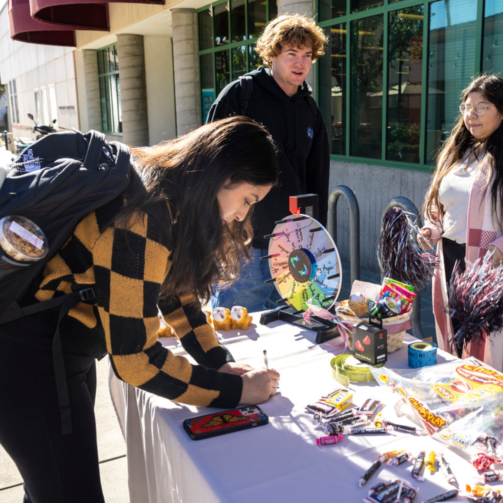 a person writing on a table with candy