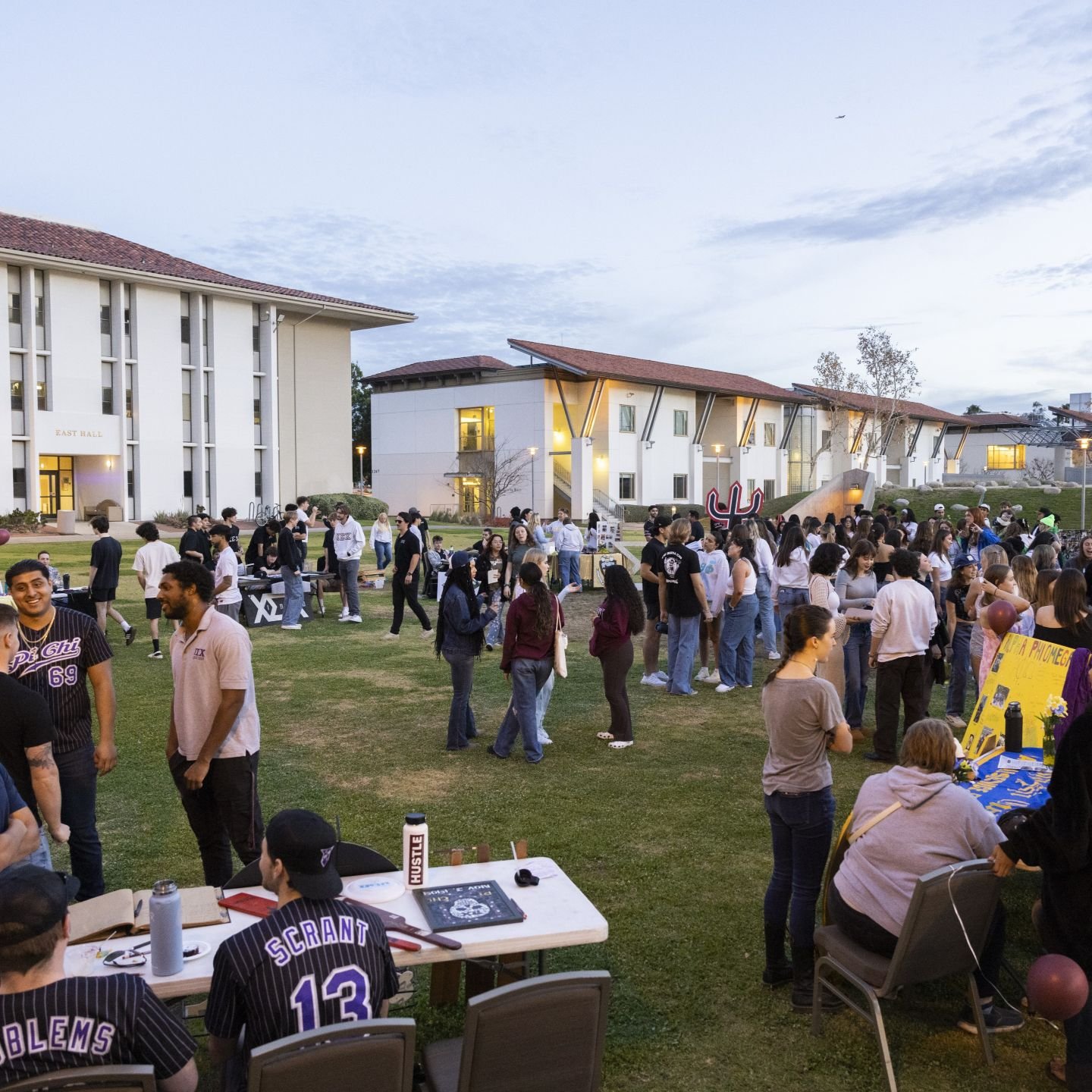 Students gathering on a campus lawn to explore club and organization booths at the Bulldog Involvement Fair.