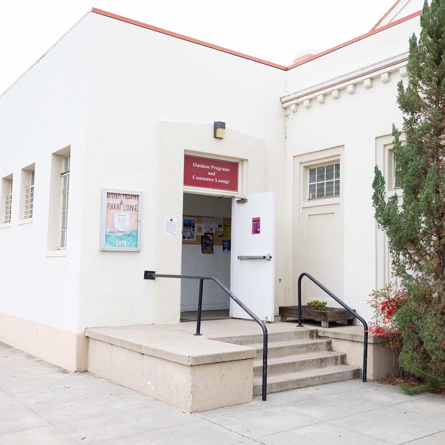 a white building with stairs and a sign