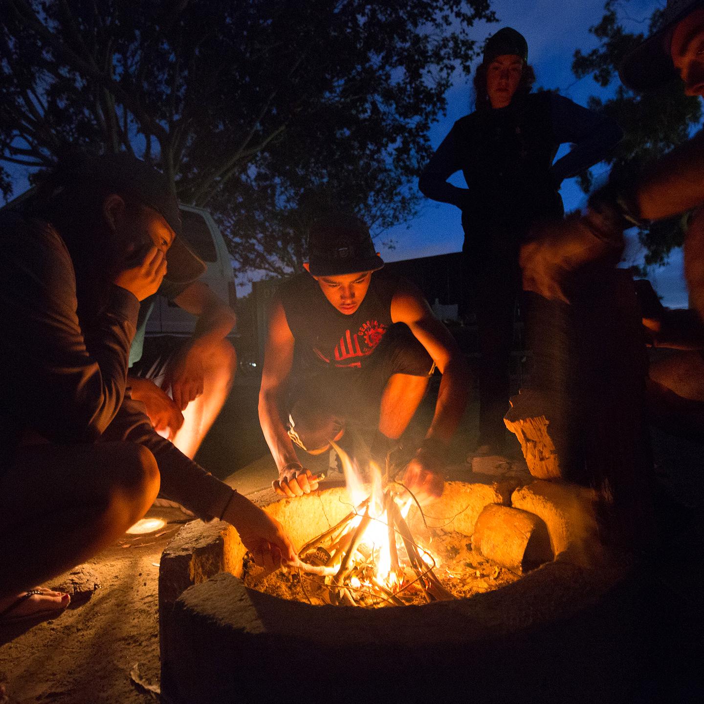 a group of people around a fire pit