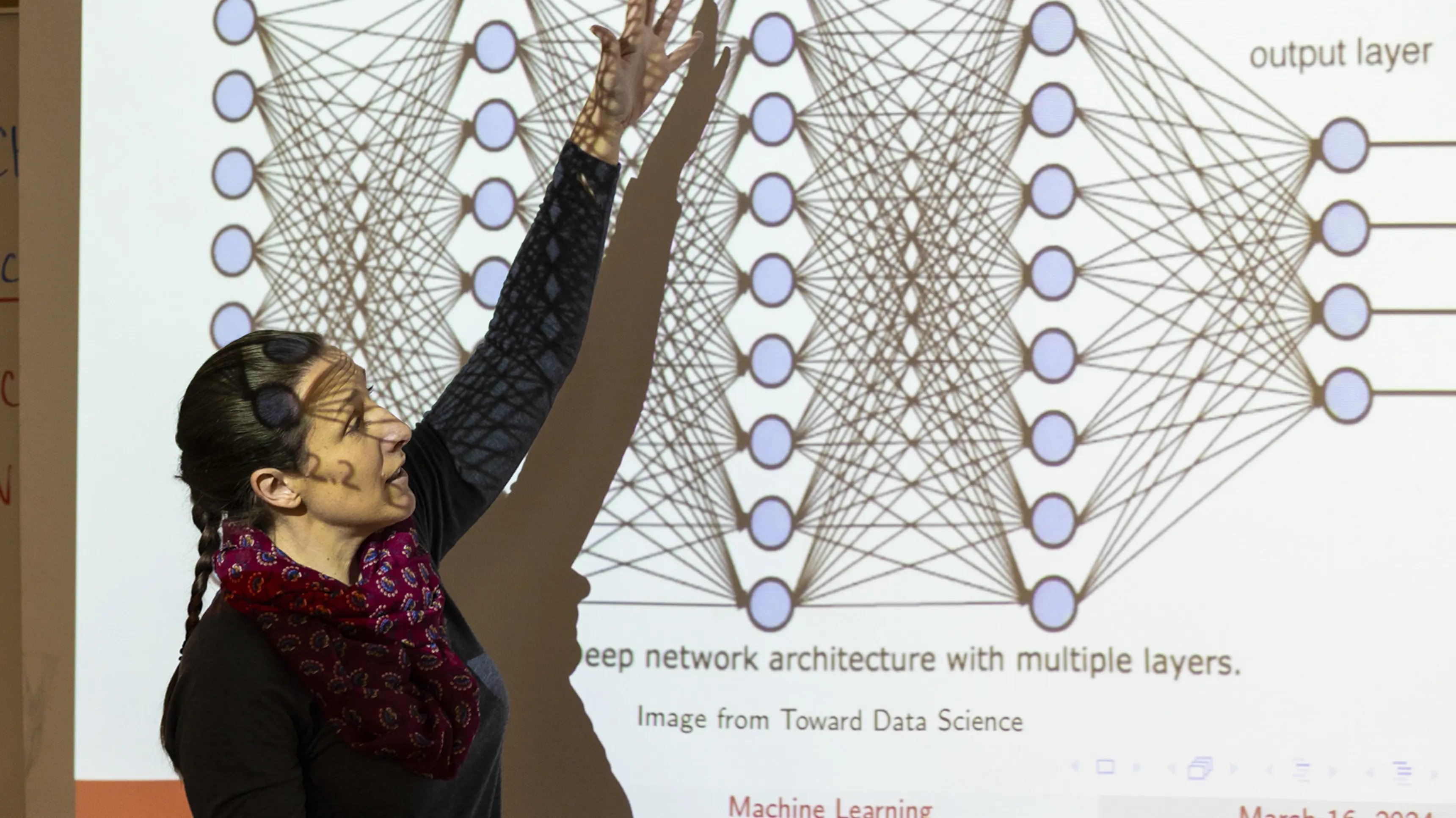 a woman standing in front of a projector screen