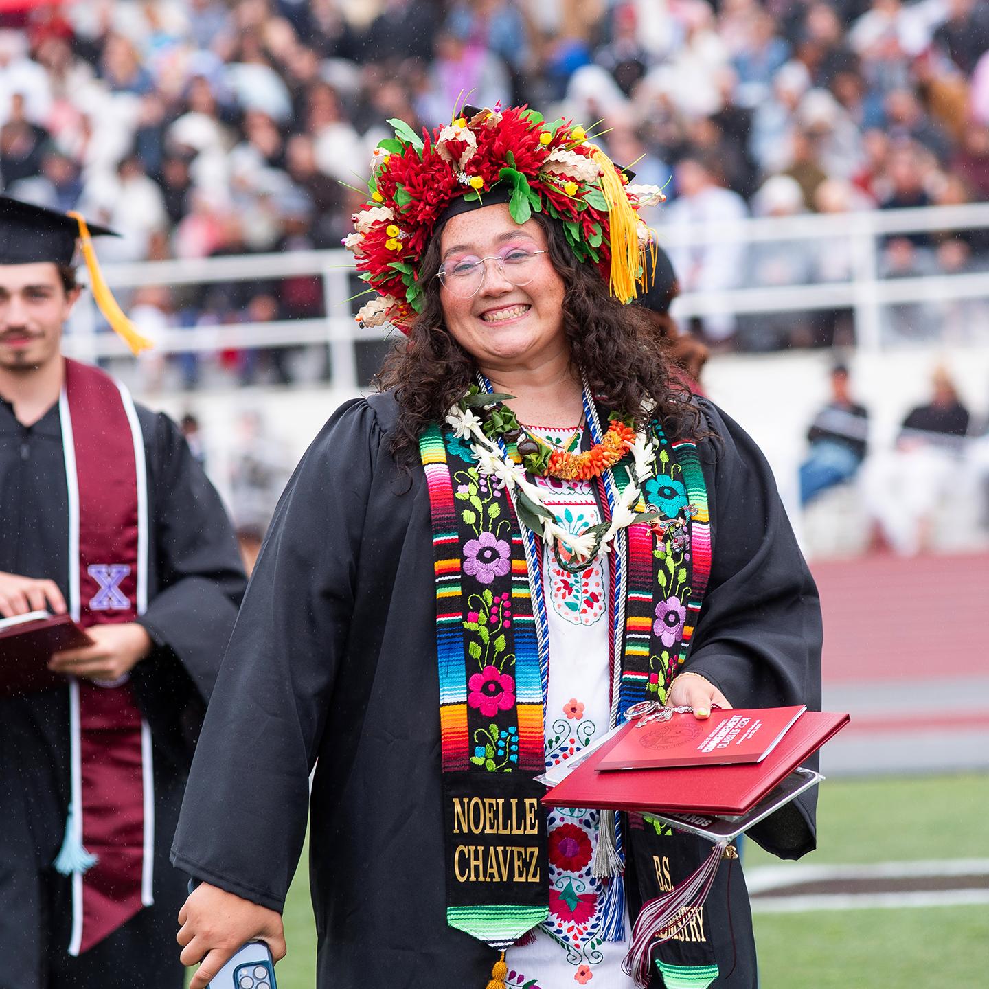 Smiling graduate wearing a lei.