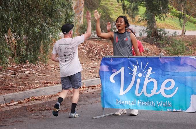 Runner participating in 5K run is greeted with a high five across the finish line in last year's festival.