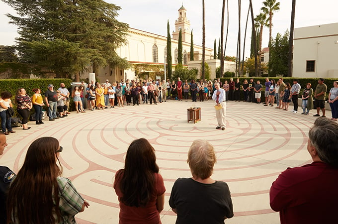 People stand in a circle around the labyrinth at the University of Redlands.