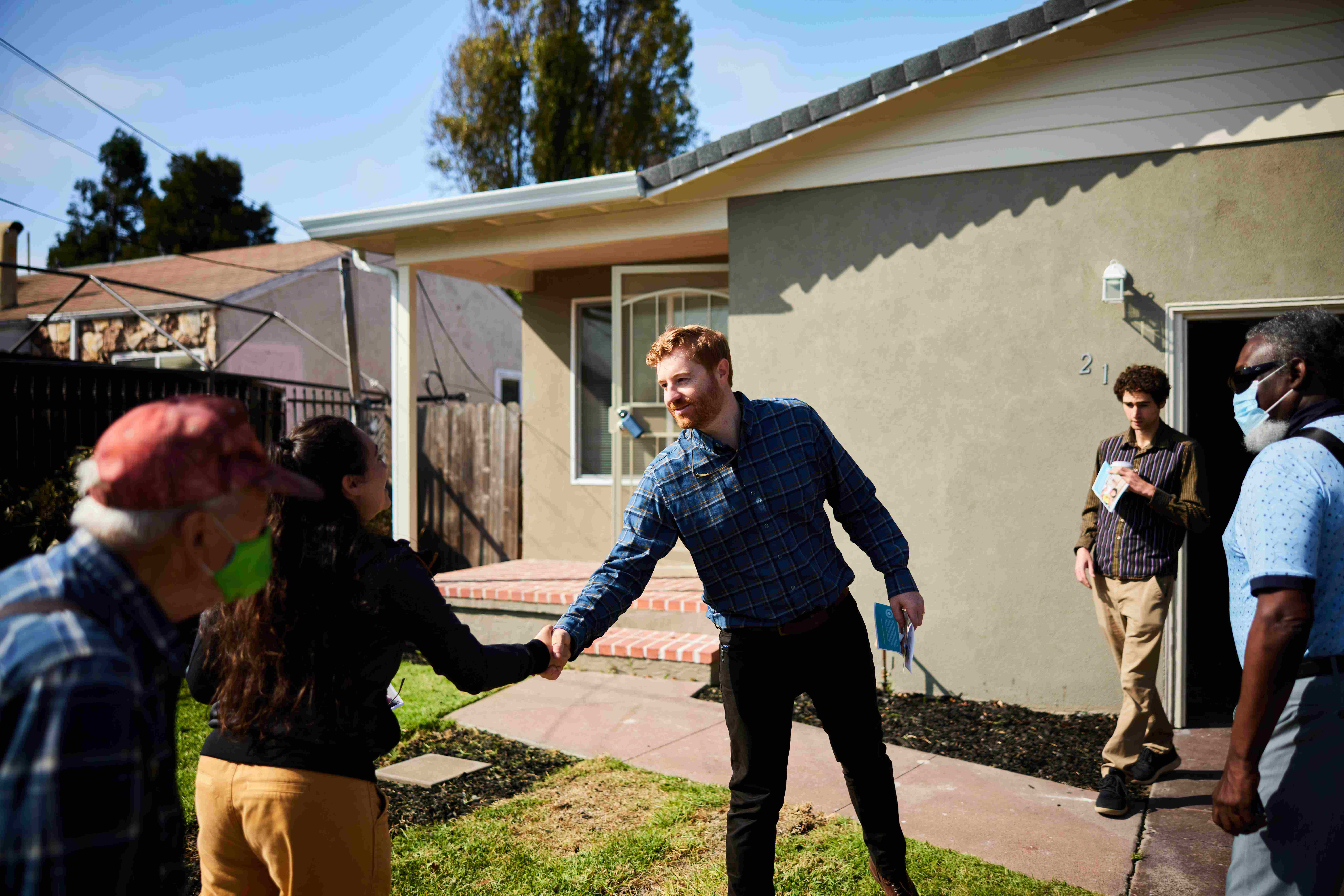 Sam Irvine shaking hands with community members
