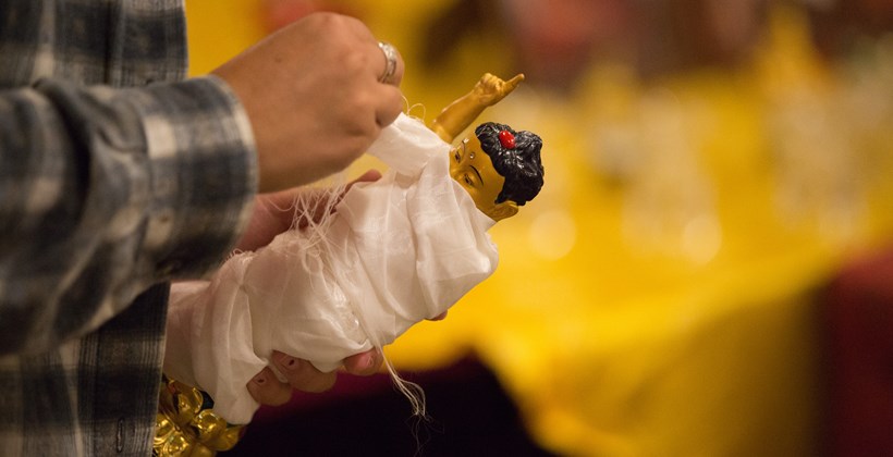 carefully wrapping a small buddhist relic