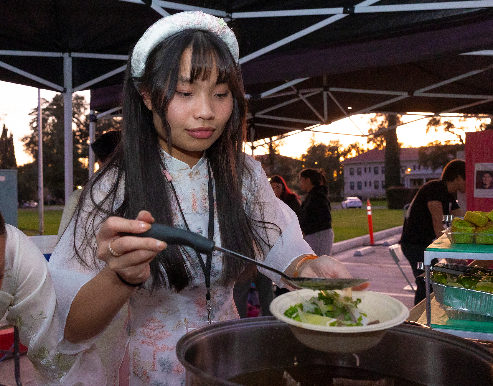 a person holding a ladle over a bowl of soup