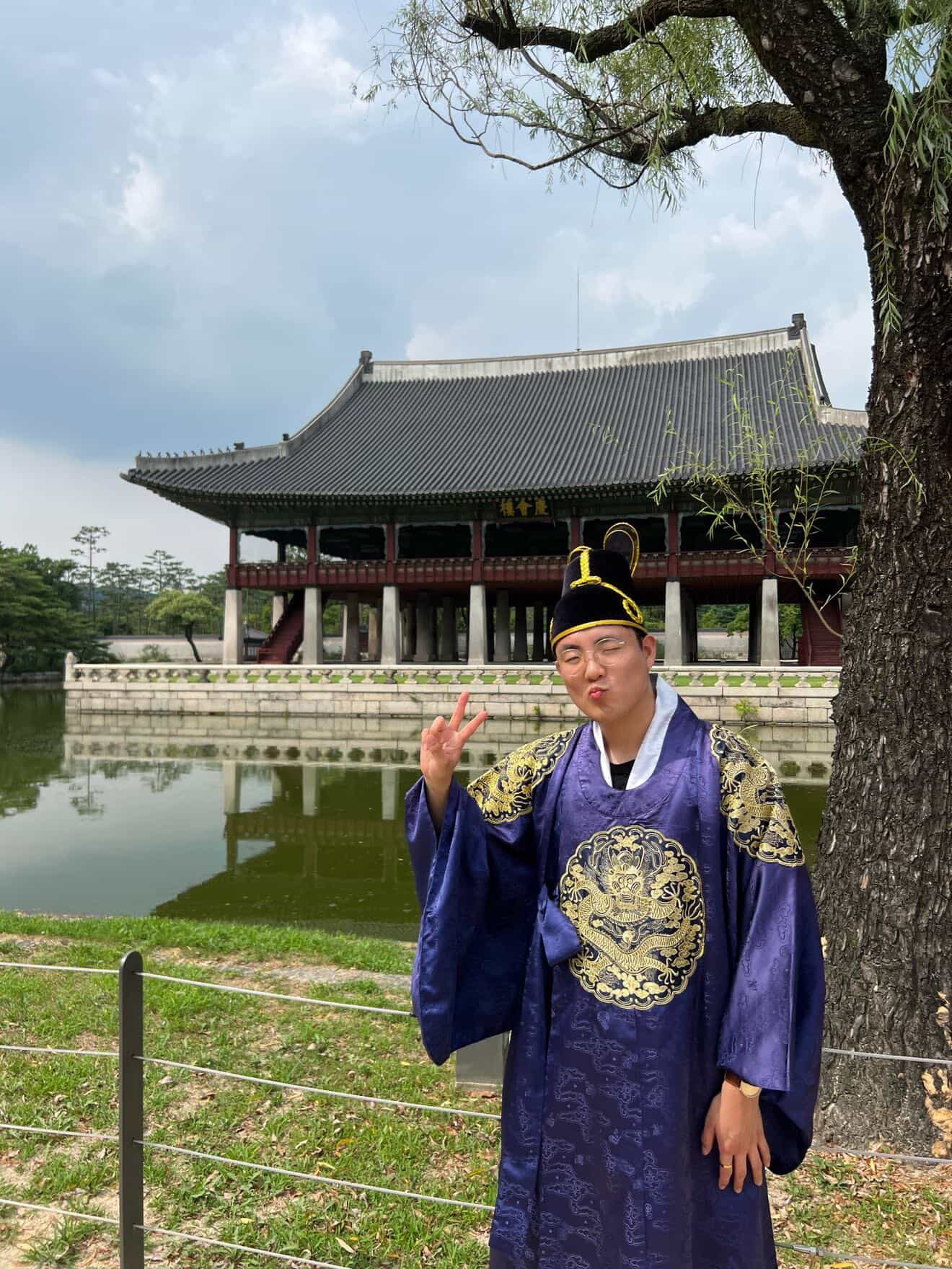 a person in a blue robe and hat standing in front of a building