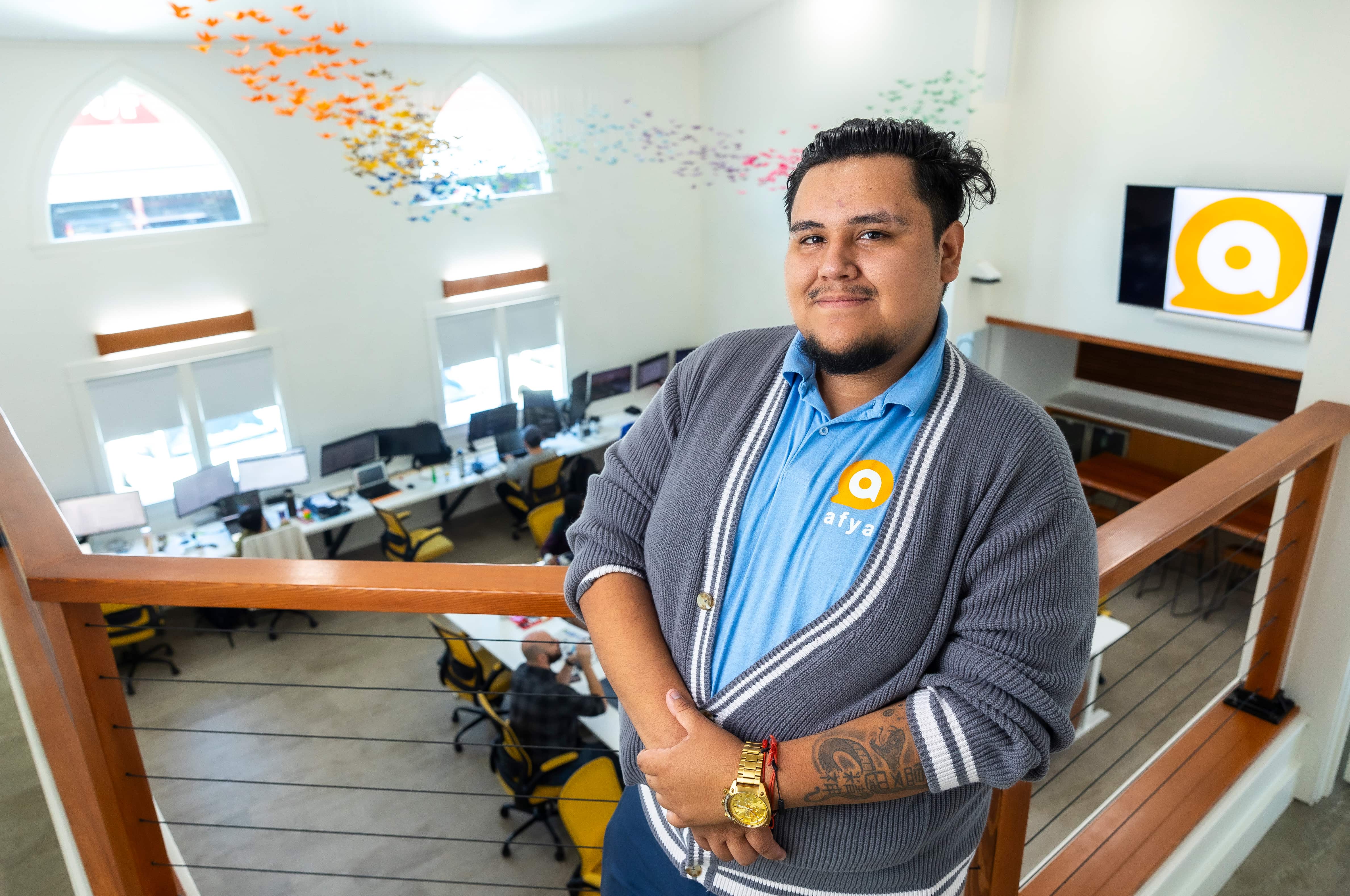 a person standing on a railing in a room with chairs and tables