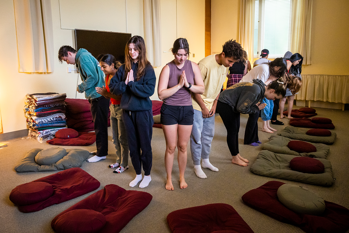 a group of people standing in a room with pillows
