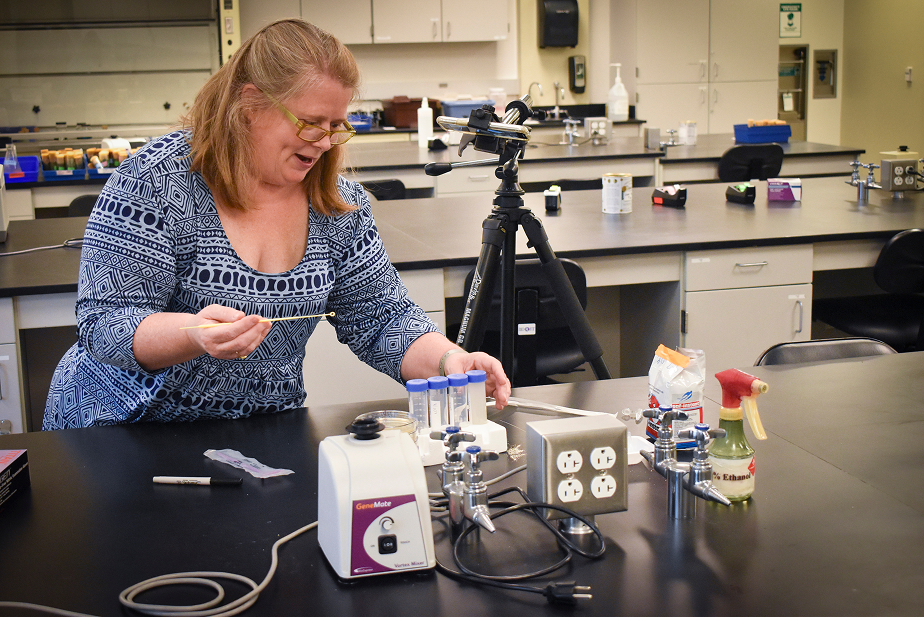 a woman sitting at a table with equipment