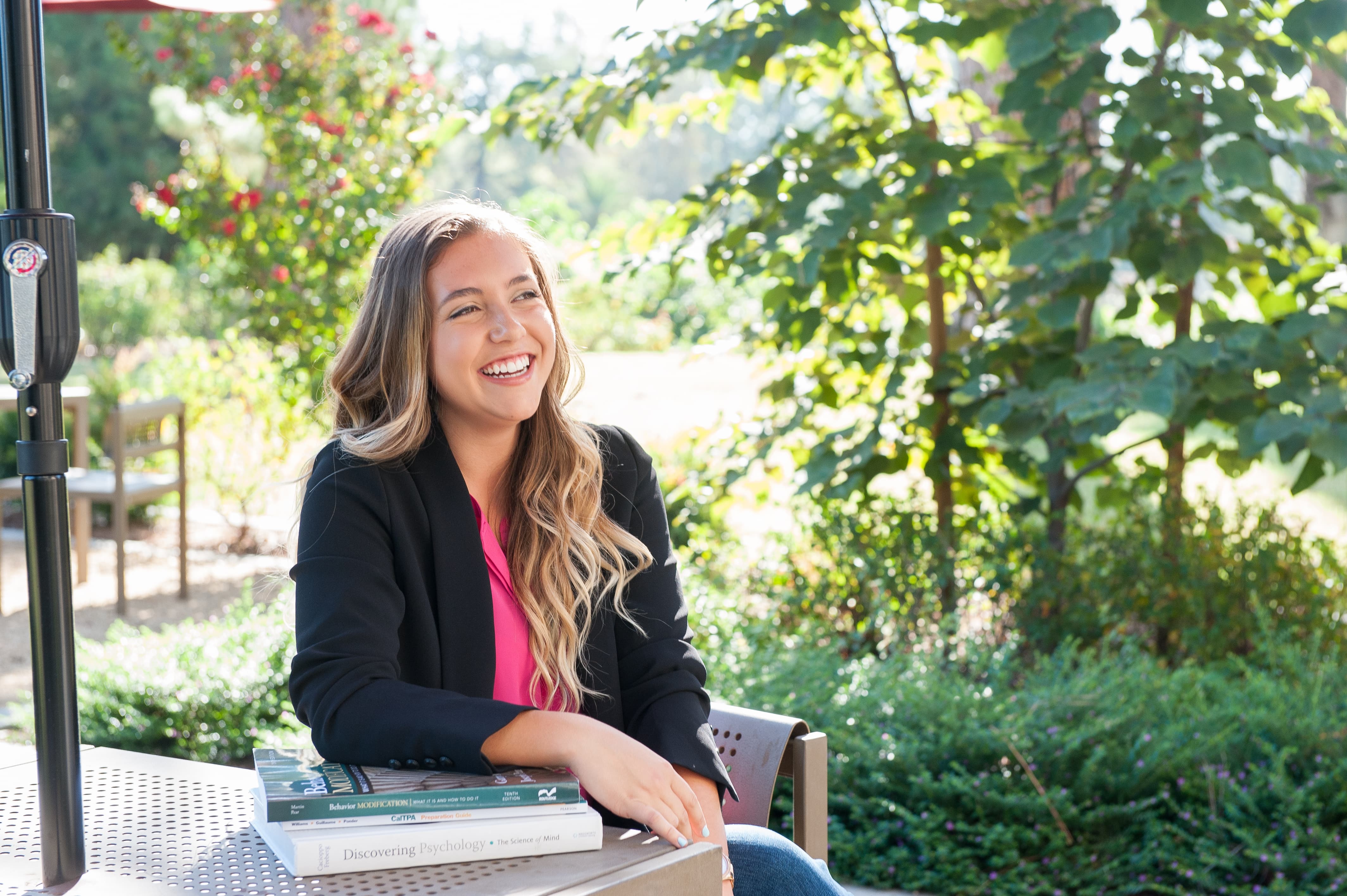 a woman sitting at a table with books