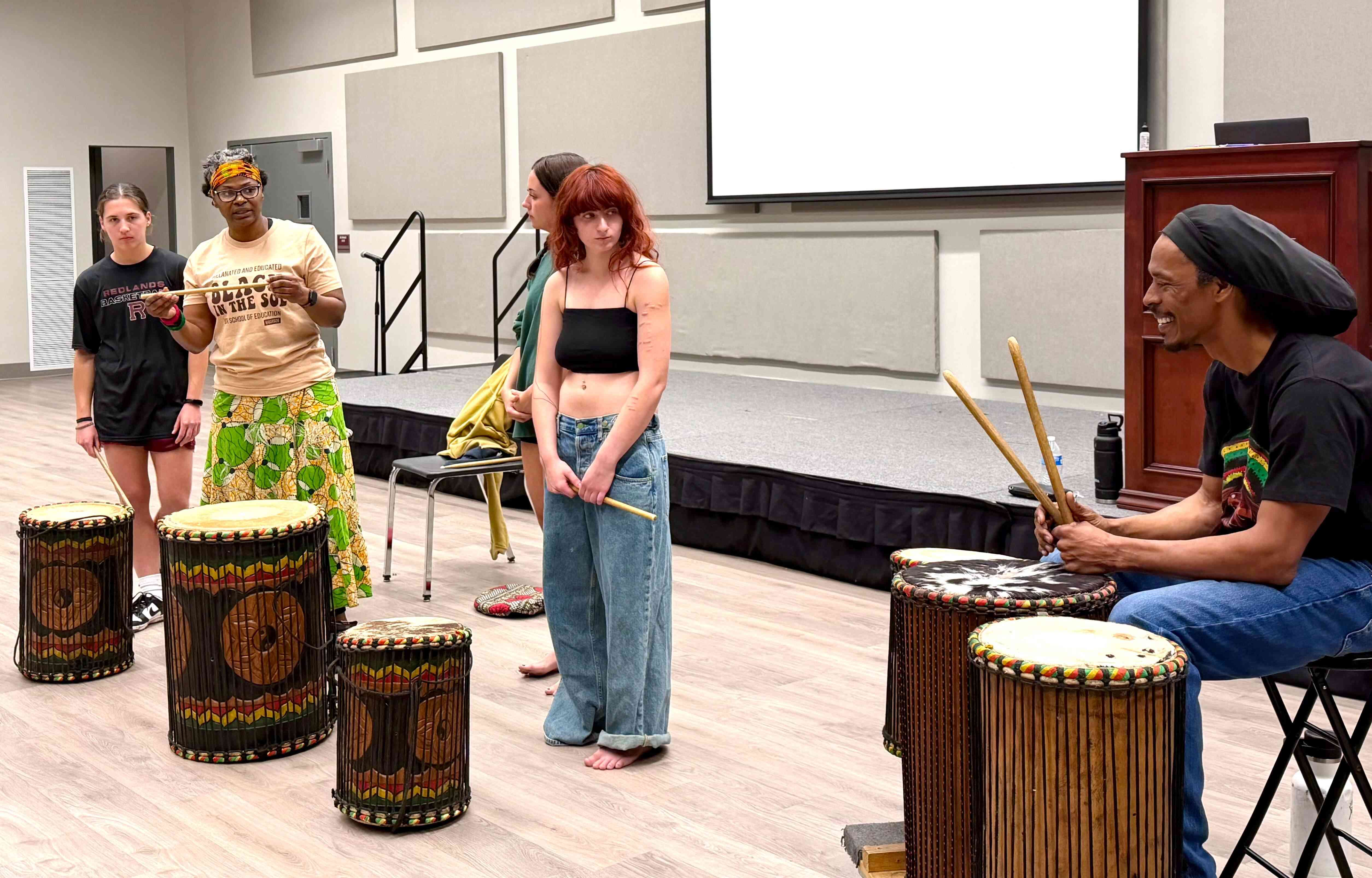a group of people standing in front of drums