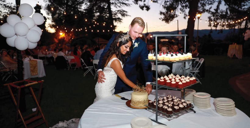 Bride and groom at reception dessert table