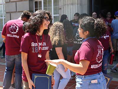 Students in Redlands shirts talking outside during Summer Bridge event